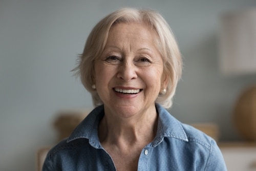 Patient smile with removable snap-in dentures in Louisville