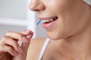 Close-up of interdental brushing for cleaning around teeth and restorations