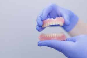 Dentist holding upper and lower removable dentures